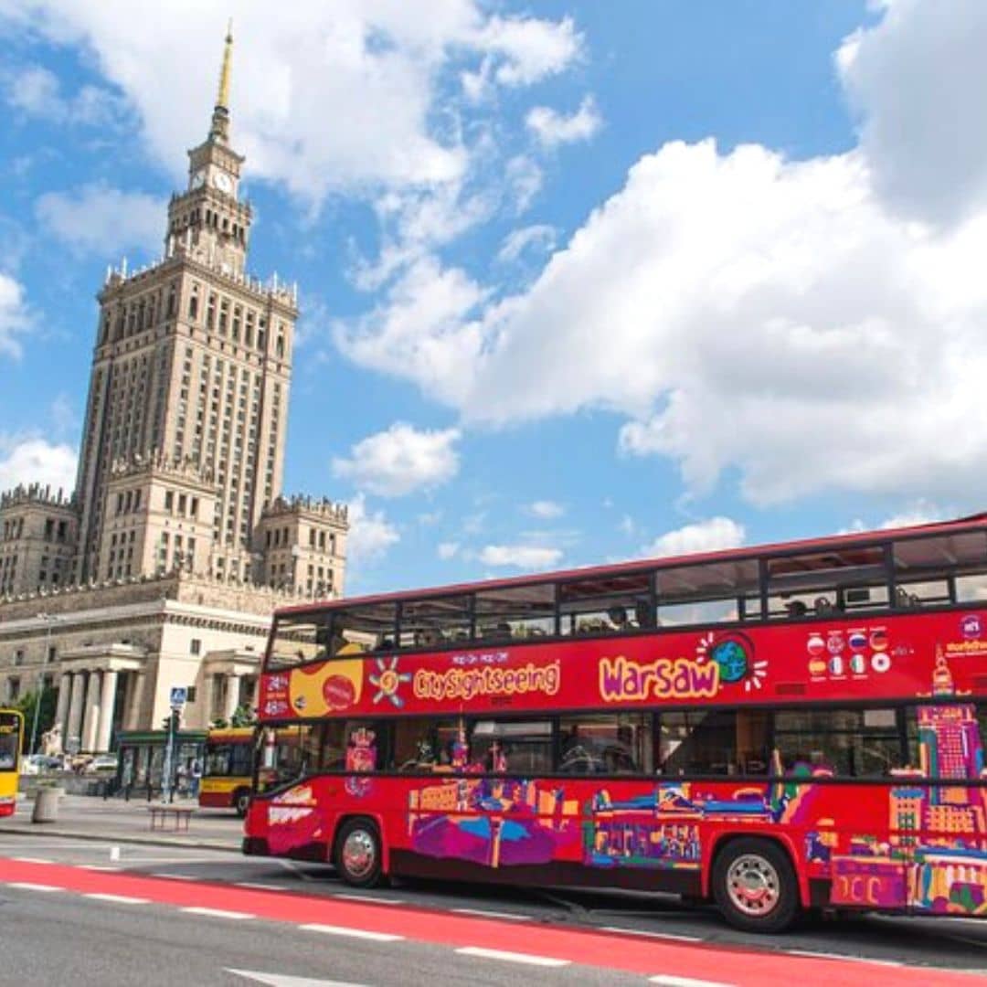 na zdjęciu widoczny jest turystyczny , dwupiętrowy autobus a w tle Pałac Kultury